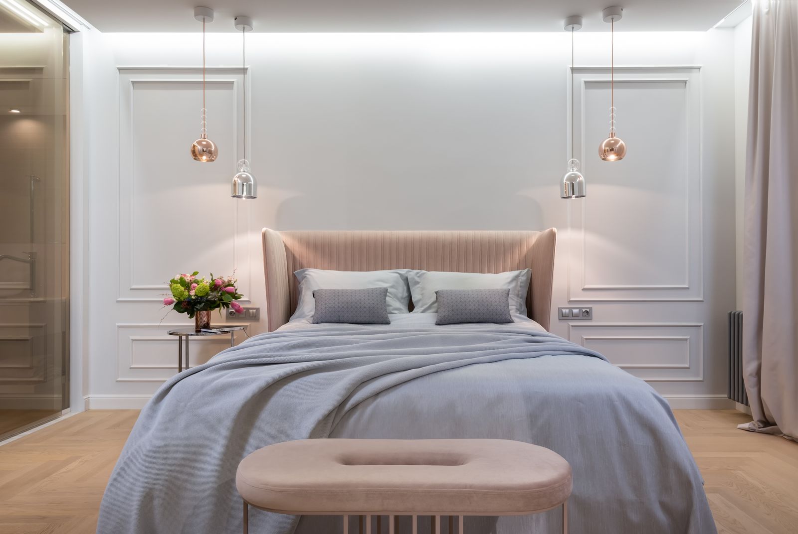 Made bed with layered linens in a bright bedroom — stock detail photo
